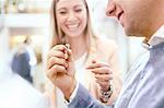 Jeweler helping man shopping for diamond ring in jewelry store