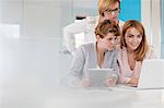 Businesswomen working at laptop and digital tablet in conference room meeting