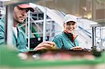 Portrait smiling female worker inspecting apples in food processing plant