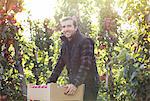 Portrait smiling male farmer harvesting apples in food processing plant