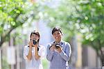 Young Japanese people taking pictures in city park