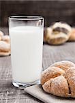 Glass of milk with bread roll for breakfast morning