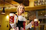Young waitress with beer mugs