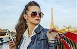 Get your bags ready for the Paris autumn sales. smiling young trendy woman with shopping bags looking into the distance near Eiffel tower