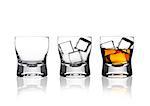 Glasss of whiskey with ice cubes with reflection on white background