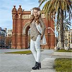 in Barcelona for a perfect winter. Full length portrait of happy young woman in earmuffs in Barcelona, Spain