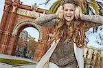 in Barcelona for a perfect winter. Portrait of cheerful young fashion-monger in earmuffs in Barcelona, Spain