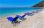 Summer morning pebbly beach with sunbeds (Albania).