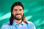 Real Cuban people and feelings, portrait of happy young hispanic man with beard and long hair from Havana, Cuba, looking at camera and smiling