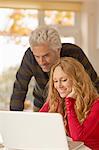 Couple using laptop at home