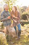 Couple laughing enjoying coffee break gardening sunny autumn garden