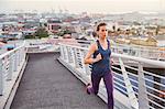 Female runner running on urban footbridge