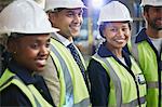 Portrait confident female worker with coworkers in distribution warehouse