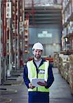 Portrait smiling worker with clipboard in distribution warehouse