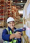 Portrait smiling worker using scanner scanning boxes in distribution warehouse