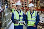 Portrait confident workers with scanners and clipboards in distribution warehouse