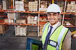 Portrait smiling manager with digital tablet in distribution warehouse