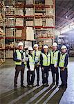 Portrait smiling manager and workers in distribution warehouse