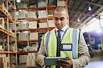 Manager using digital tablet in distribution warehouse