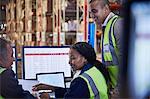 Managers meeting working at computer and laptop in distribution warehouse