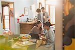 Young women college students studying at laptop at kitchen table