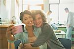 Smiling affectionate young couple taking selfie with camera phone