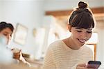 Smiling young woman texting with cell phone