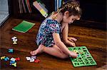 Female toddler sitting on floor playing with alphabet educational toy
