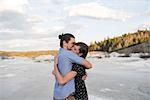 Couple hugging on snow-covered landscape, Ottawa, Ontario