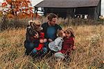 Mid adult family with three daughters together in rural field