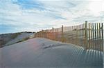 Sand dunes and wooden fence at sunset along the Atlantic Ocean at Royan, France