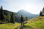 Rear view of man standing on hillside looking away, Passo Maniva, Italy