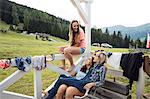 Three female adult friends sitting on porch, Sattelbergalm, Tirol, Austria