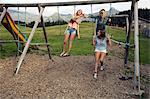 Three female adult friends playing on swings in Austrian Alps, Sattelbergalm, Tirol, Austria