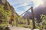 Woman walking across bridge, Höllental, Zugspitze, Garmisch-Partenkirchen, Bavaria, Germany