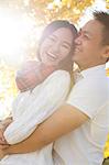 Young couple hugging in sunlit autumnal park, Beijing, China