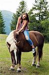 Young woman sitting on palomino horse, Sattelbergalm, Tyrol, Austria