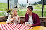 Young couple drinking coffee and talking in cafée