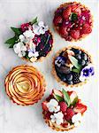 Display of variety of tart, fruit and flowers