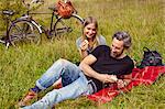 Couple eating apples at picnic in rural field
