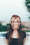 Double exposure portrait of young woman with freckles and long red hair