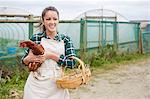 Woman on chicken farm holding chicken