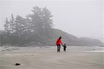 Mother and son walking on beach, Long Beach, Vancouver Island, British Columbia, Canada