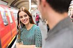 Woman on railway platform talking to friend