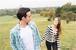 Couple in field holding hands