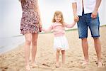 Family holding hands walking on beach