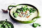 Bowl of soup garnished with blue cheese, walnut and watercress