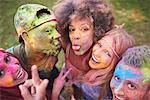 Portrait of group of friends at festival, covered in colourful powder paint