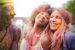 Group of friends at festival, covered in colourful powder paint
