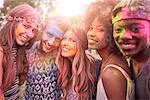 Portrait of group of friends at festival, covered in colourful powder paint